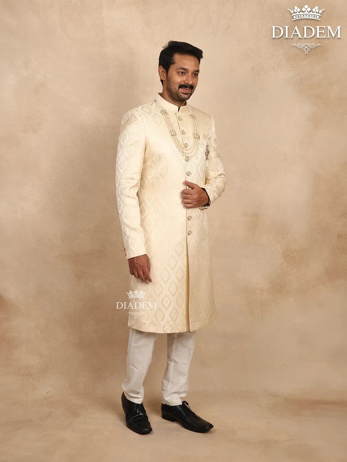 Cream Raw Silk Sherwani Suit Adorned with Floral Embroidery, Paired with Brooch and Bead Mala